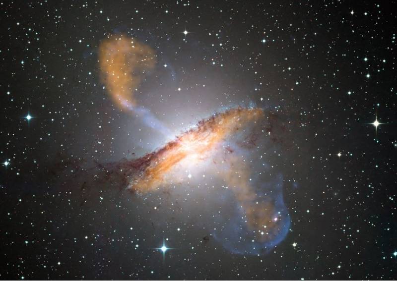Объединенное изображении галактики NGC 5128 в видимом диапазоне с данными рентгеновской обсерватории "Чандра" . Фото ESO/WFI (visible); MPIfR/ESO/APEX/A.Weiss et al. (microwave); NASA/CXC/CfA/R.Kraft et al. (X-ray)