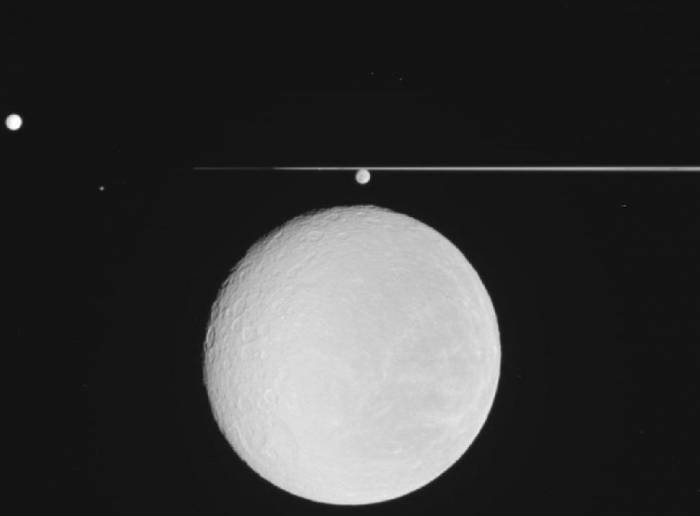 Групповой снимок спутников Сатурна. На переднем плане Рея на фоне колец Сатурна. Выше Реи и чуть ниже колец - Диона, а выше и слева от Реи - Тетис. Помимо этих спутников, можно увидеть ещё два небольших спутника Сатурна, Прометей и Эпиметей. Фото NASA / JPL / Space Science Institute.