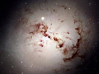 Галактика "подсвечивает" облако пыли. Фото NASA